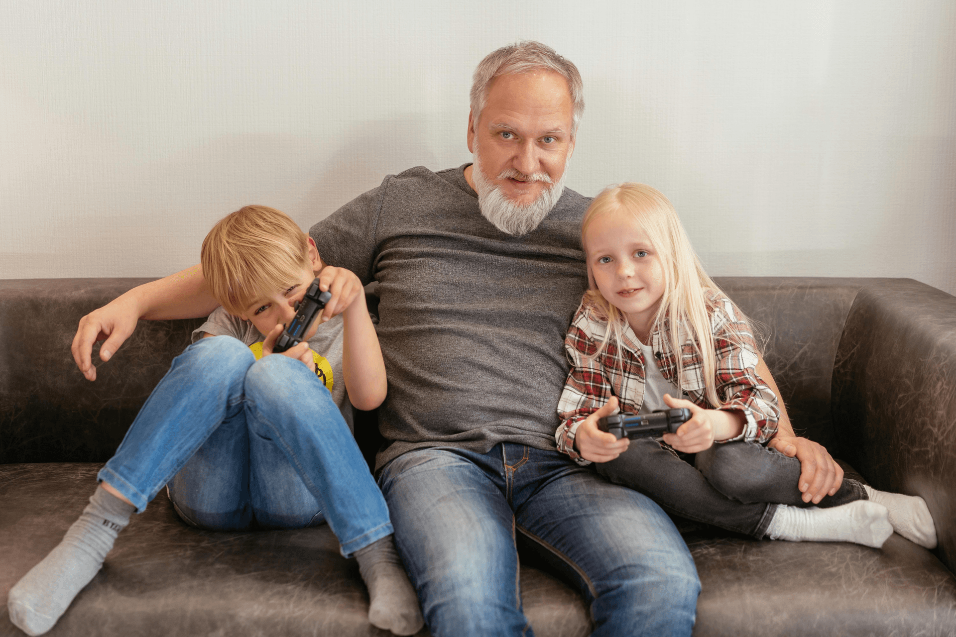 Grandparent on a couch with two grandchildren, relaxed and together.
